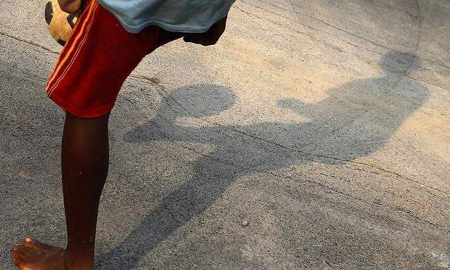 The shadow of a boy playing soccer is seen at village of Bikuy on the outskirts of Bata