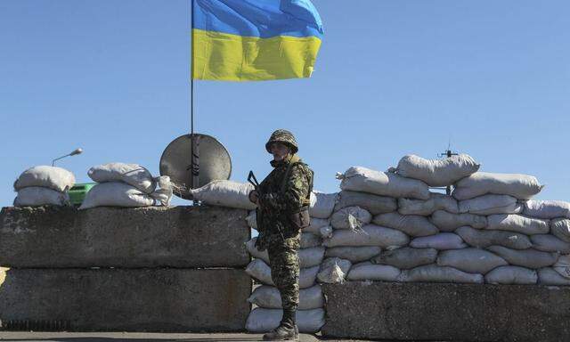 A Ukrainian serviceman stand  guard at a checkpoint near the town of Armyansk