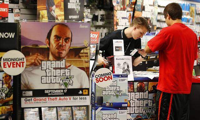 Game enthusiasts purchase the latest release of 'Grand Theft Auto V' after the game went on sale at the Game Stop store in Encinitas, California