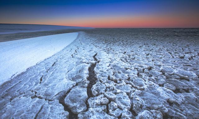 Gefrorenes Wattenmeer bei Sonnenaufgang: Wenn der Klimawandel nicht eingedämmt wird, könnte der Effekt größer werden als der Einfluss des Mondes auf die Erdrotation. 