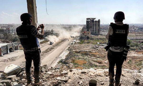 Journalisten filmen von einem beschädigten Gebäude aus das zerstörte Gebäude des al-Salam-Krankenhauses in Khan Younis am 7. April 2024, nachdem Israel Bodentruppen aus dem südlichen Gazastreifen abgezogen hat, sechs Monate nach dem Beginn des verheerenden Krieges, der durch die Angriffe vom 7. Oktober ausgelöst wurde. 