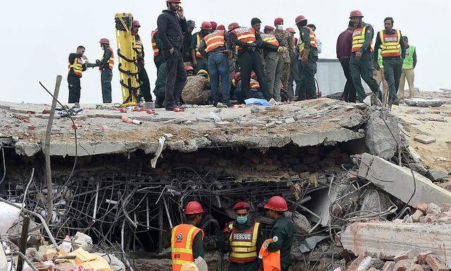 Rettungskräfte arbeiten sich mühsam durch die Trümmer der Plastiksackerl-Fabrik in Lahore.