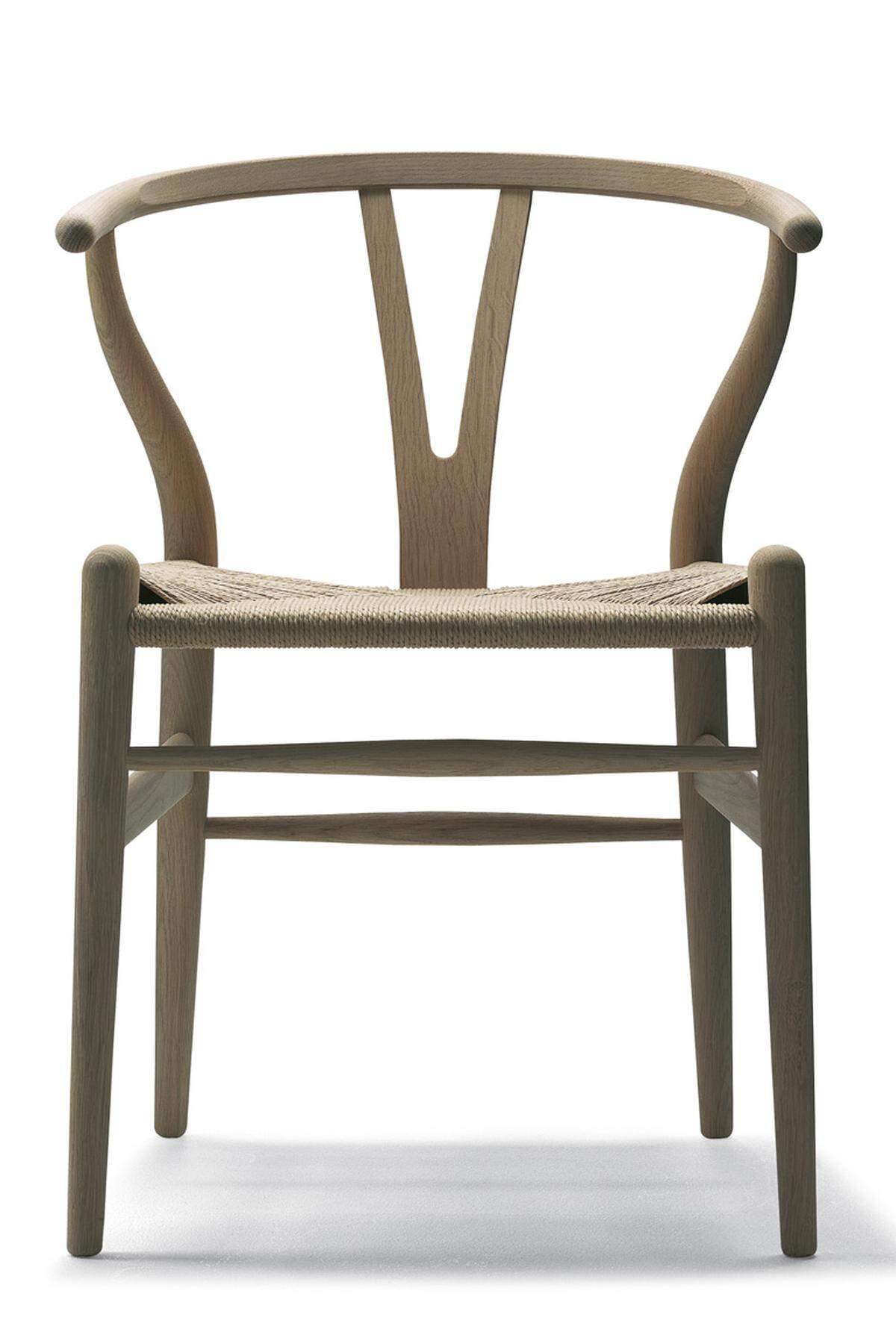 Einer der bekanntesten davon, der „Wishbone Chair“ entstand 1949, ein Jahr später begann der dänische Hersteller Carl Hansen &amp; Son mit der Produktion und hatte bis heute keinen Grund, sie einzustellen. Leicht wirkt der Stuhl, ­klassisch elegant, wie man das „Zeitlose“ so gern beschreibt, der obere Holm der Rückenlehne ist dampfgebogen, ein Meisterstück der Handwerkskunst, das in bis zu 100 Einzelschritten per Hand hergestellt wird.