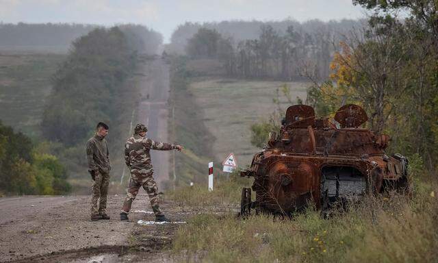 Ukrainische Soldaten untersuchen einen zerstörten russischen Schützenpanzer in der Nähe von Isjum. 