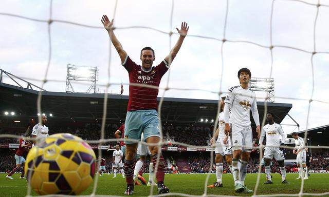 Kevin Nolan celebrates Andy Carroll of West Ham United´s second goal against Swansea City during their English Premier League soccer match at Upton Park in London