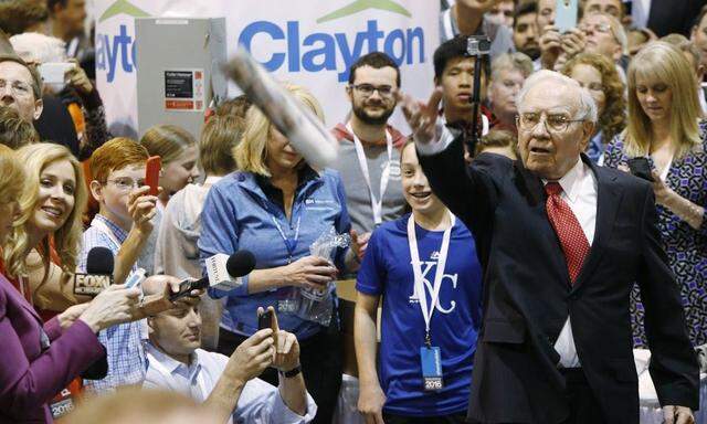 Warren Buffett participates in the newspaper tossing challenge during the Berkshire Hathaway Annual Shareholders Meeting at the CenturyLink Center in Omaha Nebraska