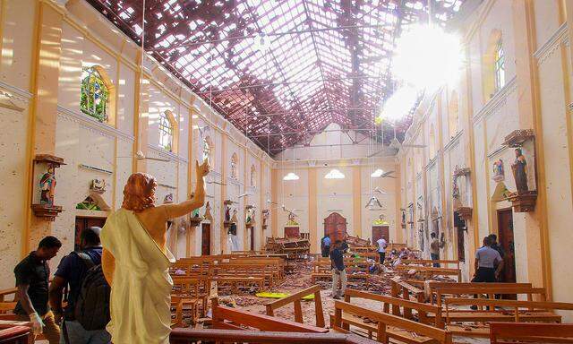 Crime scene officials inspect the site of a bomb blast inside St Sebastian´s Church in Negombo