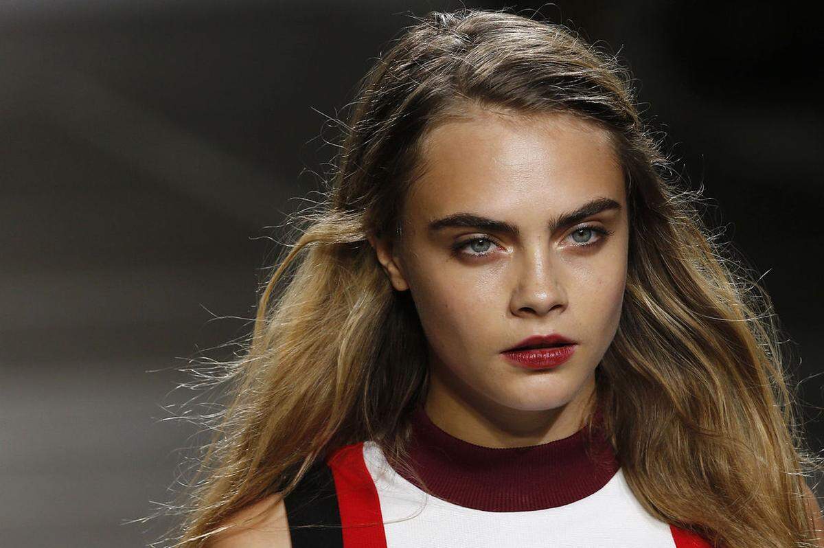 Model Cara Delevingne trägt den zeitlosen Make-up Trend rote Lippen passend zur Sommer-Kreationen von Topshop.