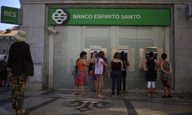 People queue to use ATMs of Portuguese bank BES in downtown Lisbon