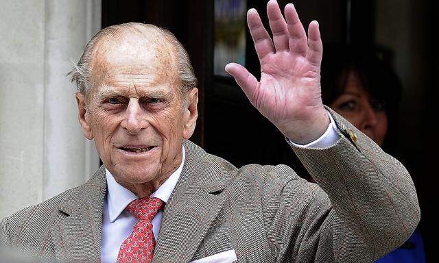 Britain´s Prince Philip waves to members of the media as he leaves the King Edward VII Hospital in London