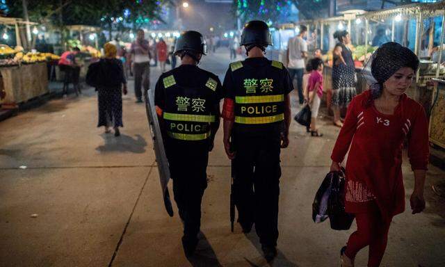 Zwei Polizisten patrouillieren in der Nähe einer Moschee in Kashgar in der Provinz Xinjiang während des Fastenmonats Ramadan