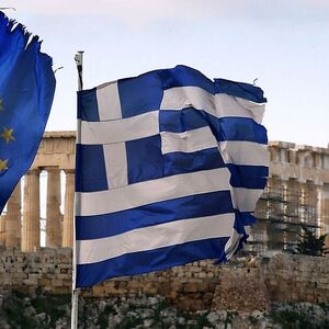 A Greek and an EU flag fly over the Greek ministry of finance in Athens