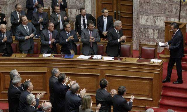 Parliamentarians applaud GreeK Prime Minister Samaras after a speech at the parliament in Athens