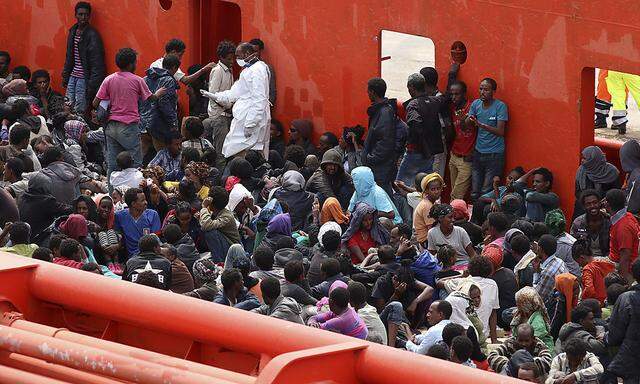 Migrants are seen aboard a navy ship before being disembarked in the Sicilian harbour of Augusta