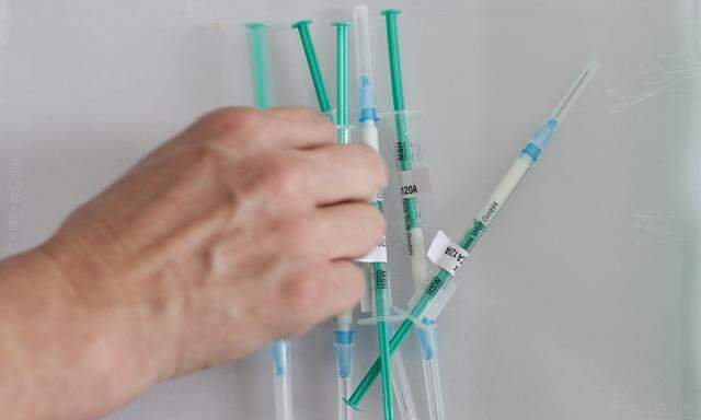 A nurse takes an injection out of a box during a counter the H1N1 swine flu virus vaccination session for medical staff at the hospital in Chur
