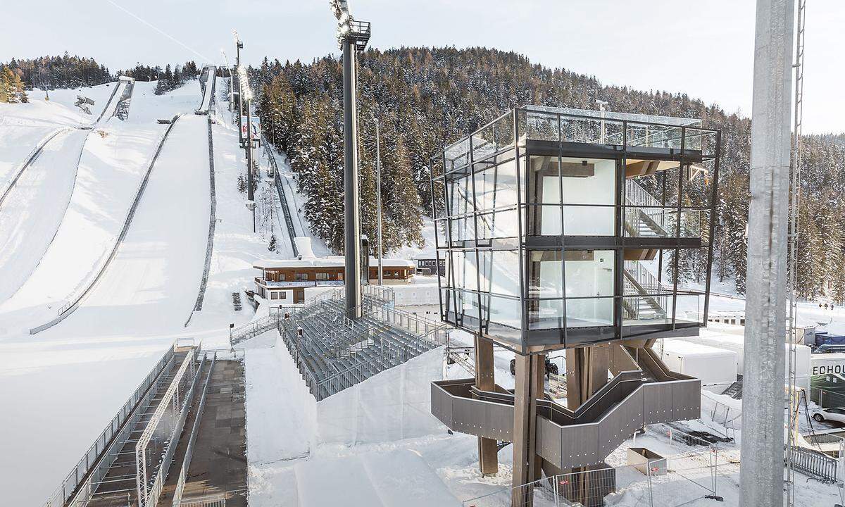 Von der Bauweise der hölzernen Jägerhochsitze inspirieren ließen sich Meissl Architects aus Seefeld bei der Konzipierung dieses Turms, der Seefeld als Olympia- und WM-Ort über die aktuellen nordischen Ski-weltmeisterschaften hinaus im Gespräch halten soll. Die Umsetzung erfolgte in zeitgemäßer Zimmermannstechnik, die drei verglasten Außenwände geben einen großzügigen Blick auf die Wettkampfarena frei. Der WM-Turm dient während der laufenden Bewerbe der Zeitnehmung, dem Platzsprecher und der Rennleitung als Zentrale. (red., 26. 2. 2019)