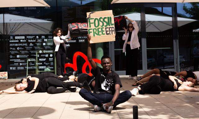 Nicholas Omunuk hält beim Klimastreik in Alpbach ein Schild mit dem Schriftzug „Fossil Free EFA“ in die Höhe. 