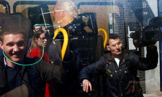 Julian Assange (Mitte) wird in einem Polizeifahrzeug von der Botschaft weggebracht.