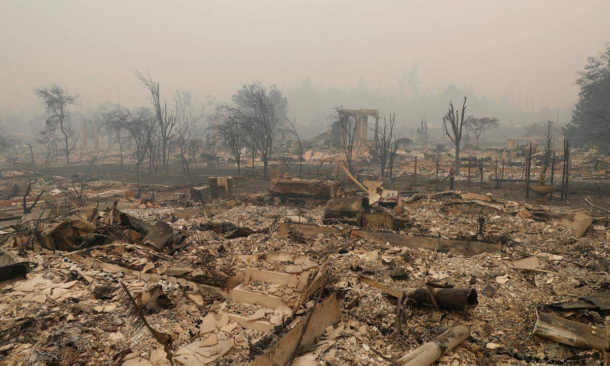 Bei starken Winden hatten sich mehr als ein Dutzend Brände ausgebreitet. Feuerwehrchef Ken Pimlott bezifferte die Zahl der aktiven Feuer in der Weinbauregion am Dienstag (Ortszeit) auf 15. Im Bild: ein zerstörtes Viertel in Santa Rosa  