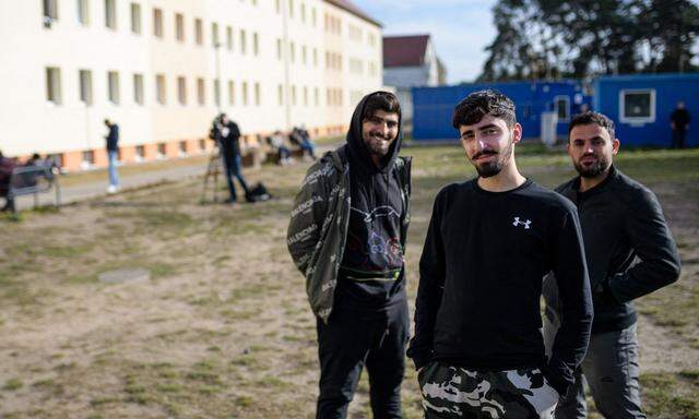 Drei Männer posieren Ende Oktober vor der Erstaufnahmeeinrichtung in Eisenhüttenstadt. Mehr als 5000 Menschen sind in den vergangenen zwei Monaten von Belarus über Polen nach Deutschland gelangt.
