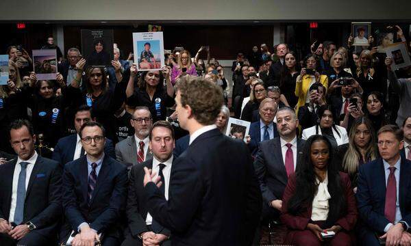 Mark Zuckerberg im US-Senat während Eltern Bilder ihrer Kinder in die Höhe halten.