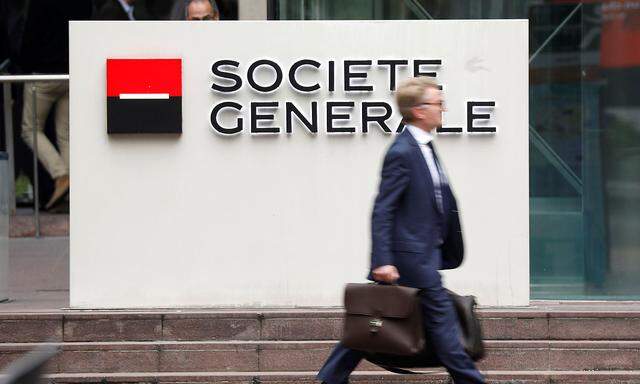 FILE PHOTO: A man passes by the logo on the headquarters of French bank Societe Generale at the financial and business district of La Defense at Puteaux near Paris