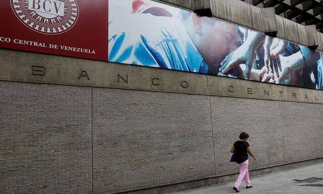 FILE PHOTO: A woman walks outside of the Venezuela's Central Bank in Caracas