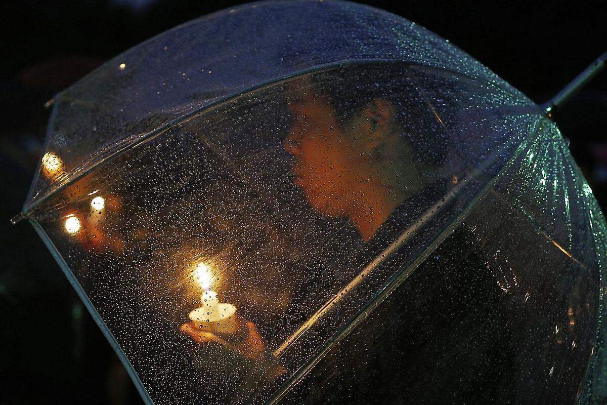 Und natürlich auch vor Regen kann ein Regenschirm schützen - hier eine Kerze und ihren Träger bei einer Solidaritäts-Demonstration in Boston, Massachusetts.