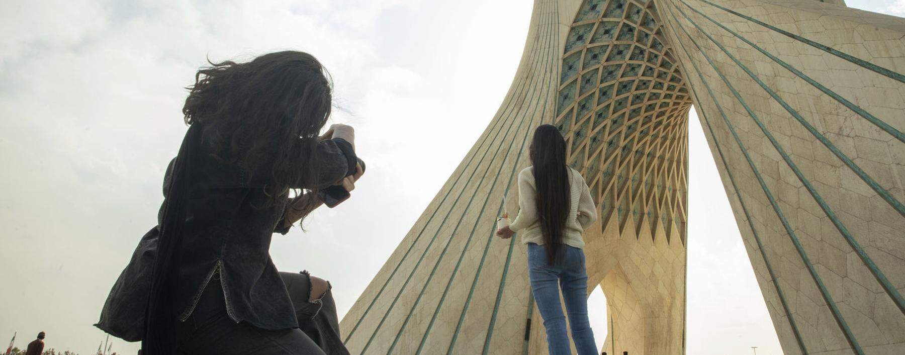 Zwei junge Frauen unter dem Azadi-Bogen in Teheran – ohne Kopftuch.