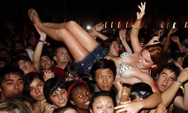 A woman is helped from the crowd during the Strokes concert at the Coachella Valley Music & Arts Festival in Indio