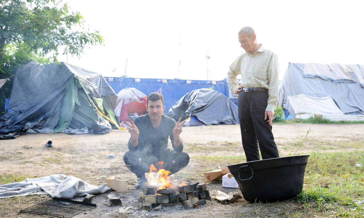 in paar Dinge haben sich in diesem einen langen Jahr nicht geändert. Sobald die Flüchtlinge hier eine Kamera sehen, spreizen sie Zeige- und Mittelfinger. „Peace“. 
