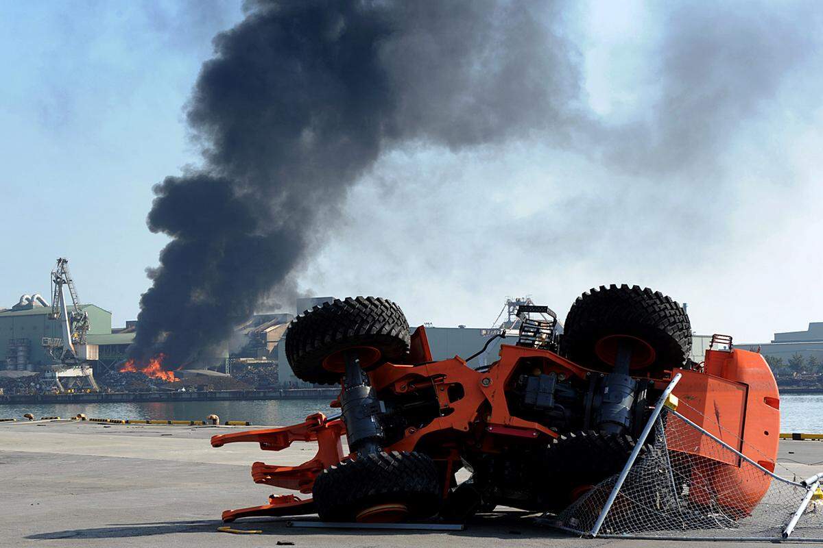 Donnerstag (17. März): Ein zerstörter Stapler vor dem brennenden Hafen von Sendai.