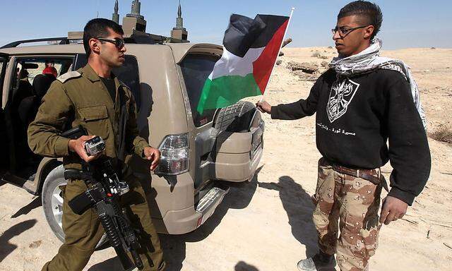 Konfronation in der Westbank. Ein palästinensischer Aktivist versucht auf einem israelischen Militärfahrzeug eine Palästinenserfahne anzubringen.