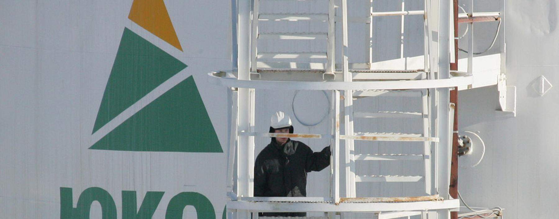 A worker climbs stairs of oil container at pumping station near Priobskoye oil field in Siberia.