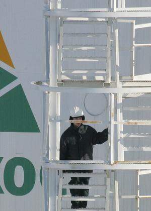 A worker climbs stairs of oil container at pumping station near Priobskoye oil field in Siberia.