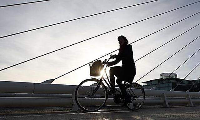 A woman cycles through the financial district of Dublin