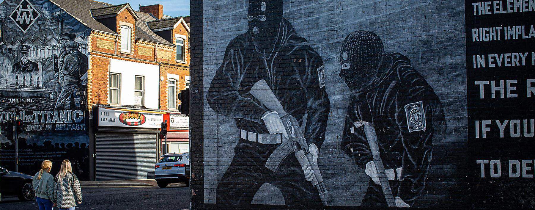 Straßenszene mit Wandgemälde loyalistischer Paramilitärs in der Newtownards Road in Belfast.