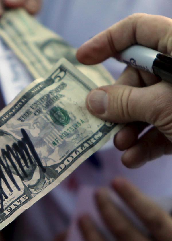 US-Präsidentschaftskandidat Donald Trump signiert Dollar-Noten und wirbt um die Stimmen von Bitcoin-Fans.
