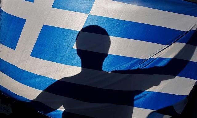 A nationalist holds a Greek flag during a protest against government plans to build the first official mosque in an Athens neighborhood