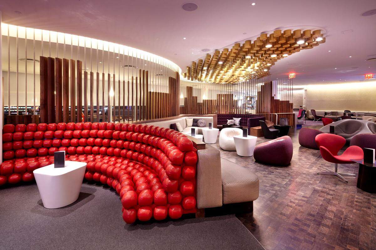 Mit knallroten Lederpoufs, einer geschwungenen Bar und lässigen Eames Chairs beeindruckt das Virgin Atlantic Clubhouse am New Yorker Flughafen JFK auch sieben Jahre nach seiner Eröffnung.