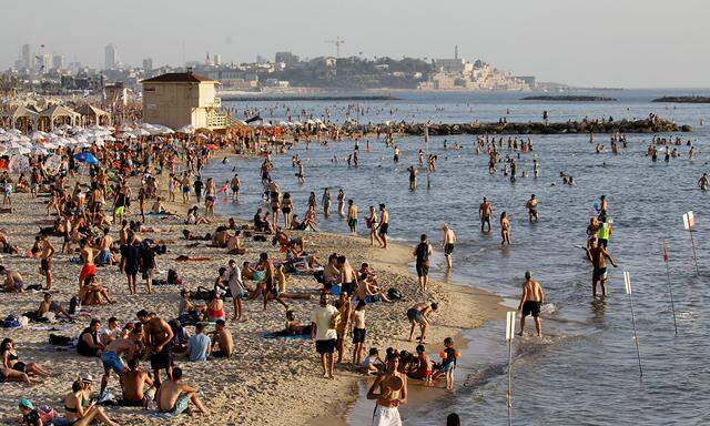 FILE PHOTO: Beachgoers hang out on the shore of the Mediterranean Sea in Tel Aviv as coronavirus disease (COVID-19) restrictions ease in Israel
