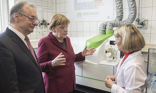 German Chancellor Merkel and the State Premier of the federal state of Saxony-Anhalt, Haseloff speak with employee Mroczek as they tour an analytical laboratory at the chemical park in Leuna
