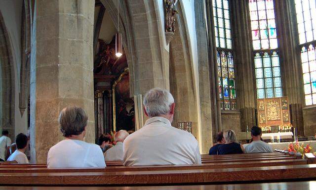 Wenige Besucher in einer Kirche bei der Sonntagsmesse