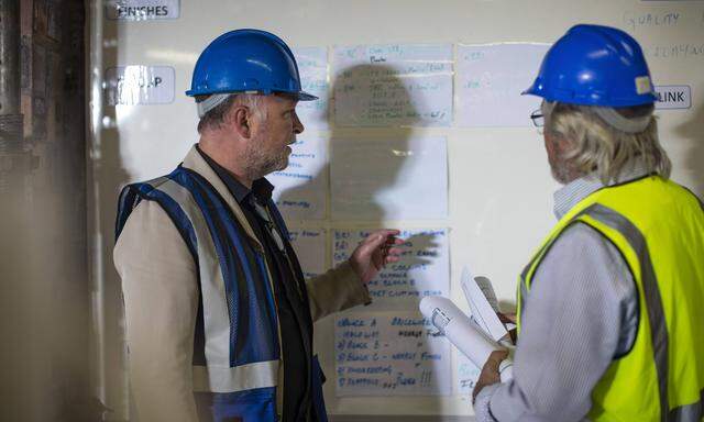 Construction worker and engineer discussing project in site office model released Symbolfoto propert