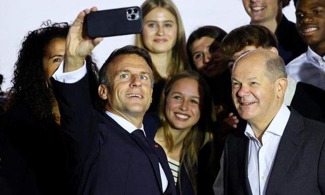 Ein Selfie in der Klausur-Pause: Emmanuel Macron und Olaf Scholz mit Fans. Die zweitägigen Gespräche waren von den Ereignissen im Nahen Osten überschattet. 