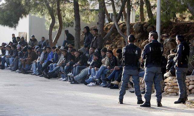 Migrants from North Africa rest at the immigration centre on the southern Italian island of Lampedusa