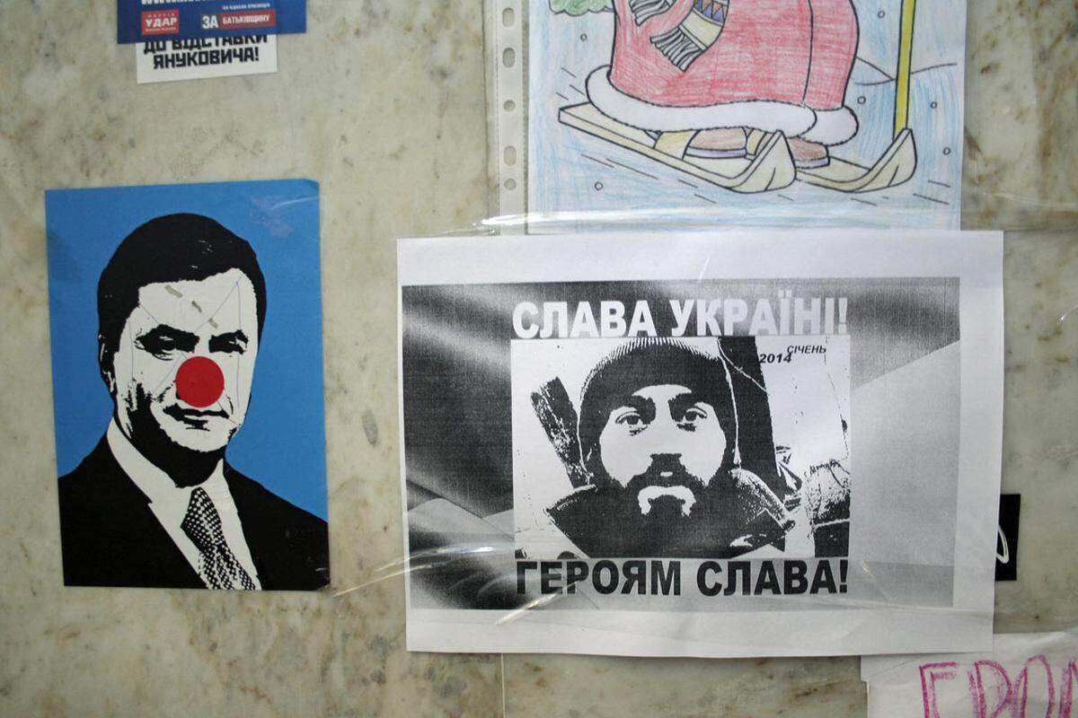 Die Wände säumen Poster mit diversen Bekundungen. Hier eines, auf dem Staatschef Janukowitsch als Clown dargestellt wird. Daneben wird ein Todesopfer betrauert.