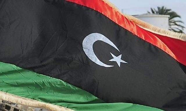 A Libyan waves the Kingdom of Libya flag as he celebrates the first anniversary of the uprising that 