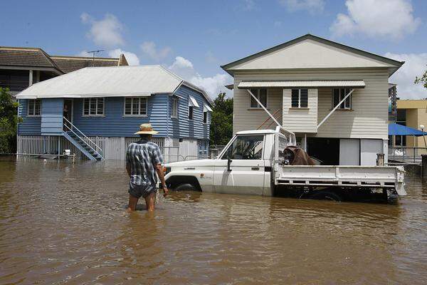 Der Brisbane River rast nach den verheerenden Regenfällen im Hinterland durch sein Flussbett und ist an zahlreichen Stellen bereits über die Ufer getreten.