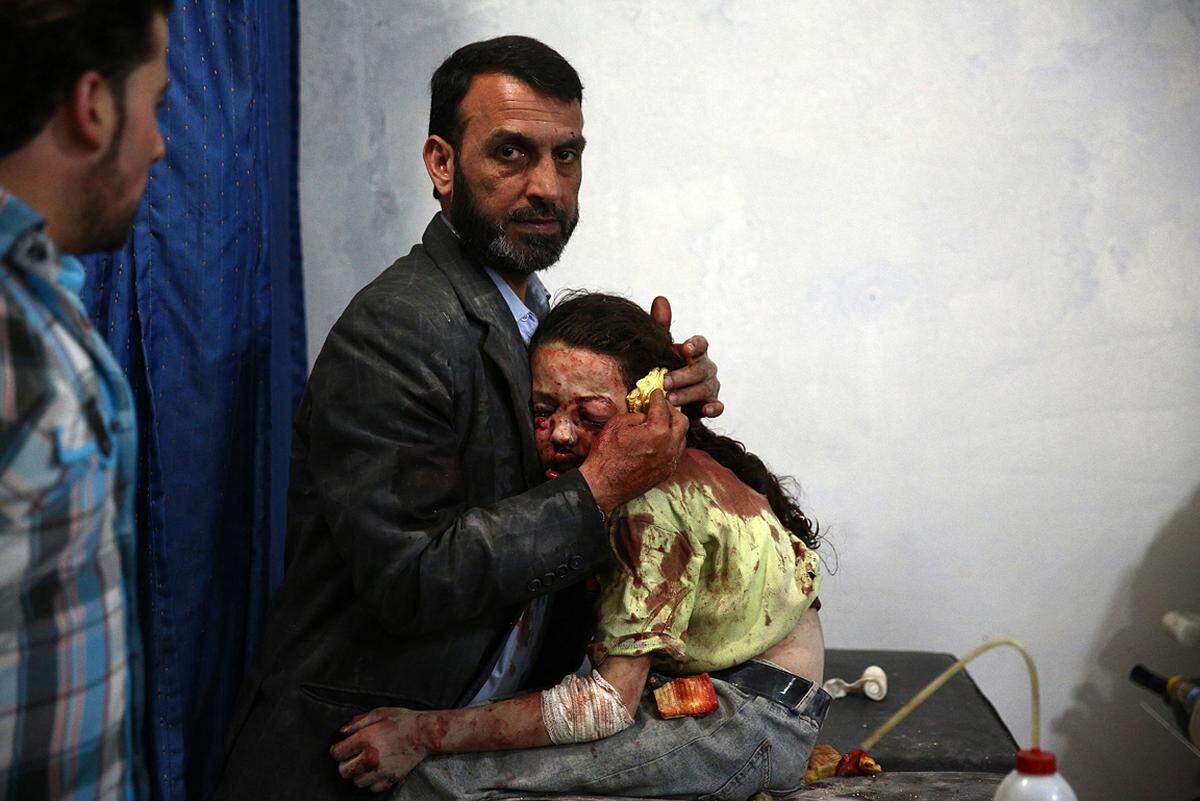 Abd Doumany, Syrien, 2015, Agence France-Presse Ein verwundetes syrisches Mädchen wird von einem Verwandten getröstet, während es am 11. März 2015 in einem improvisierten Krankenhaus in Douma, Syrien, auf einen Arzt wartet. 